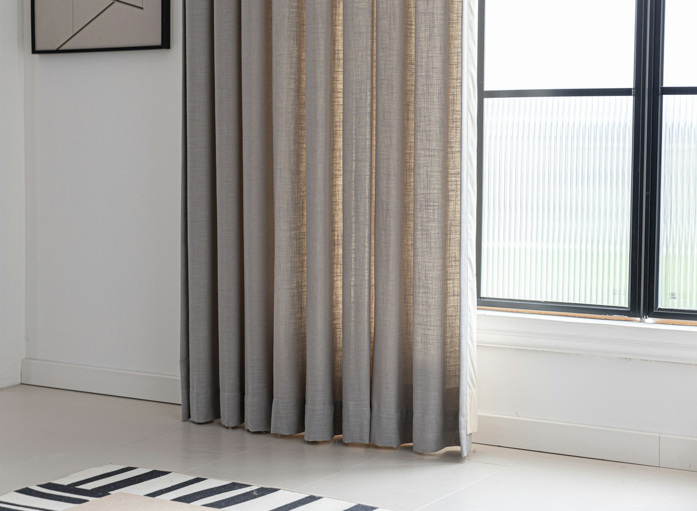 Linen curtains beside a black-framed window