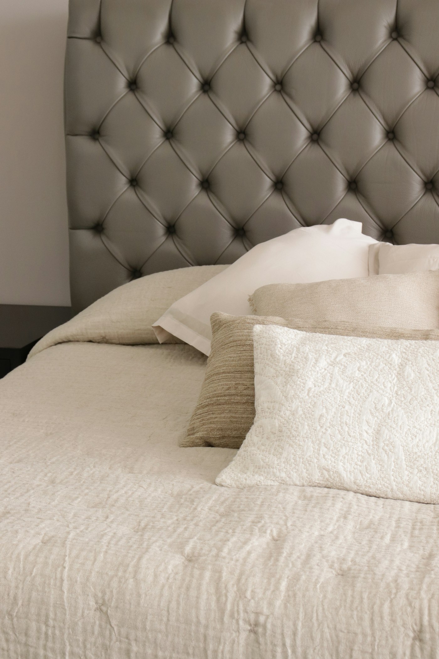 Layered bed linen and cushions on a bed