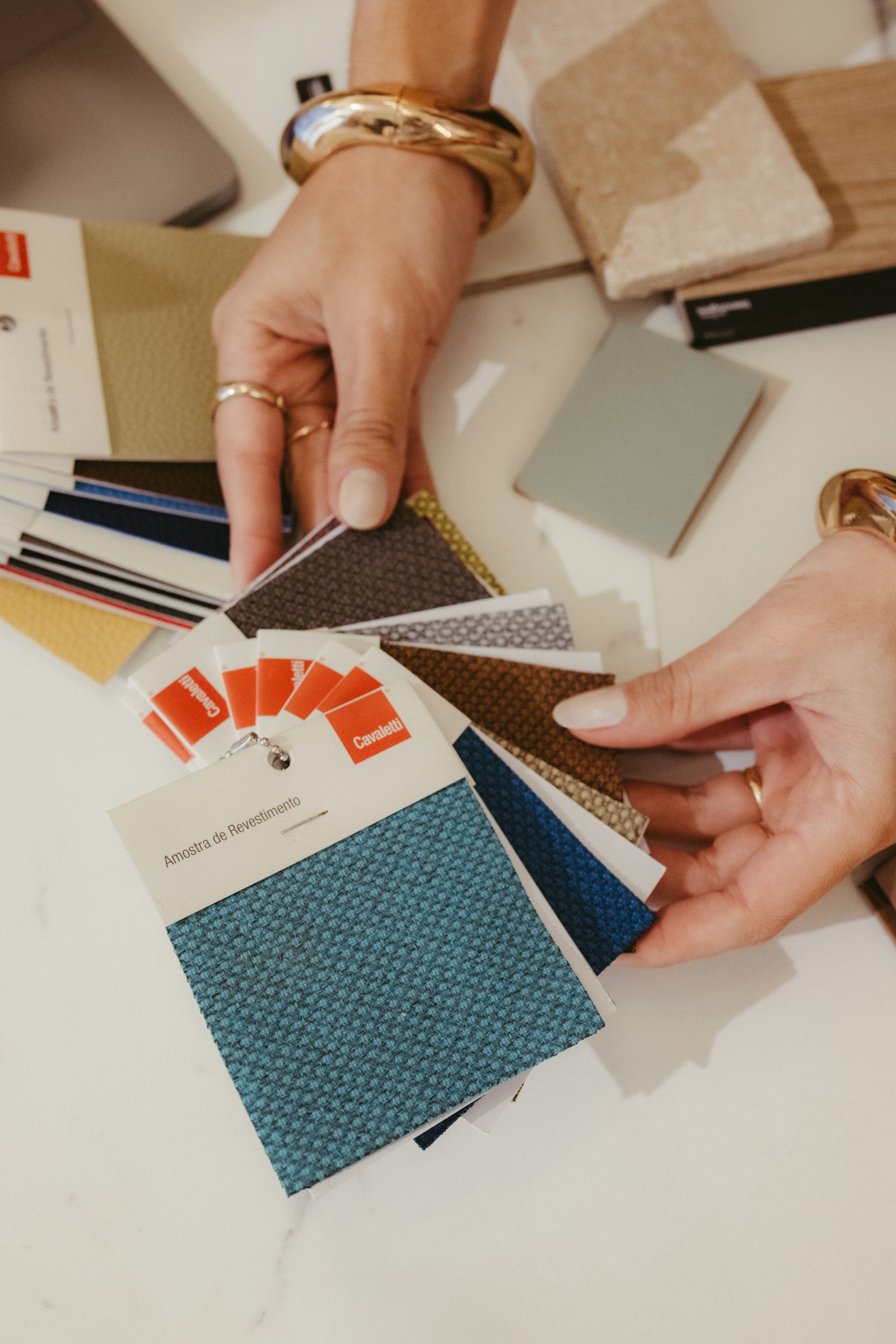 Hands choosing between fabric swatches